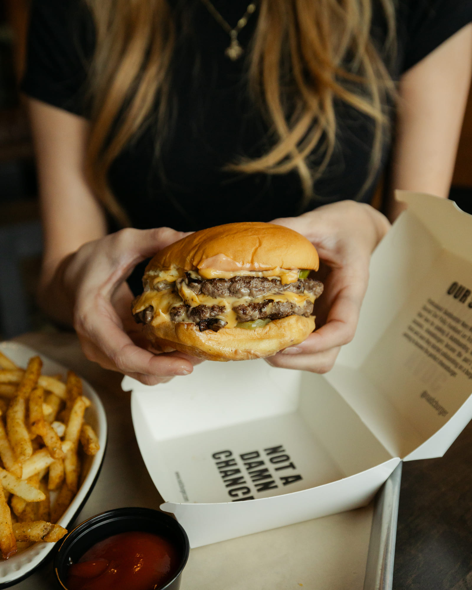 Mouthwatering, gourmet-style burger made with a stack of thick, juicy beef patties layered with oozing melted, golden-yellow cheese ready to serve.