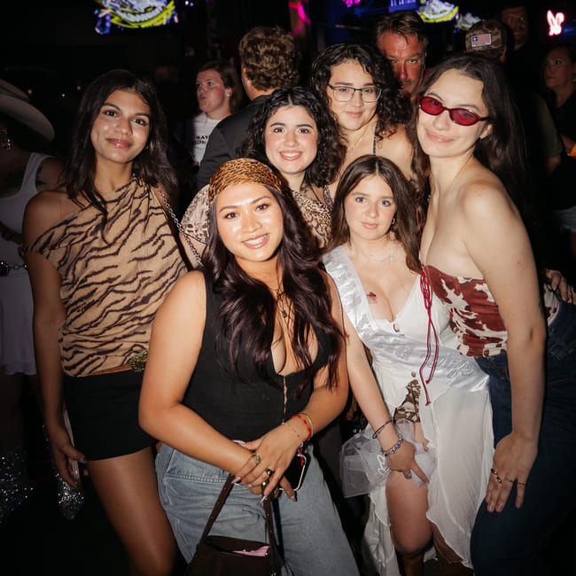 Group of guests posing together for a photo at a lively nightlife event.